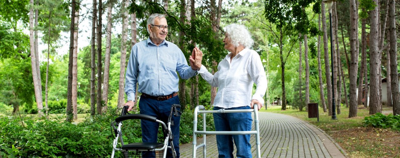 Zwei Senioren gehen mit Rollator spazieren