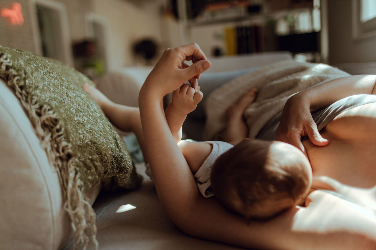 Une femme allaite son bébé en position couchée