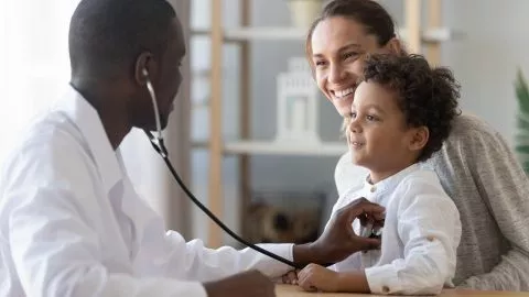 Arzt untersucht Kind auf Gedeigstörung