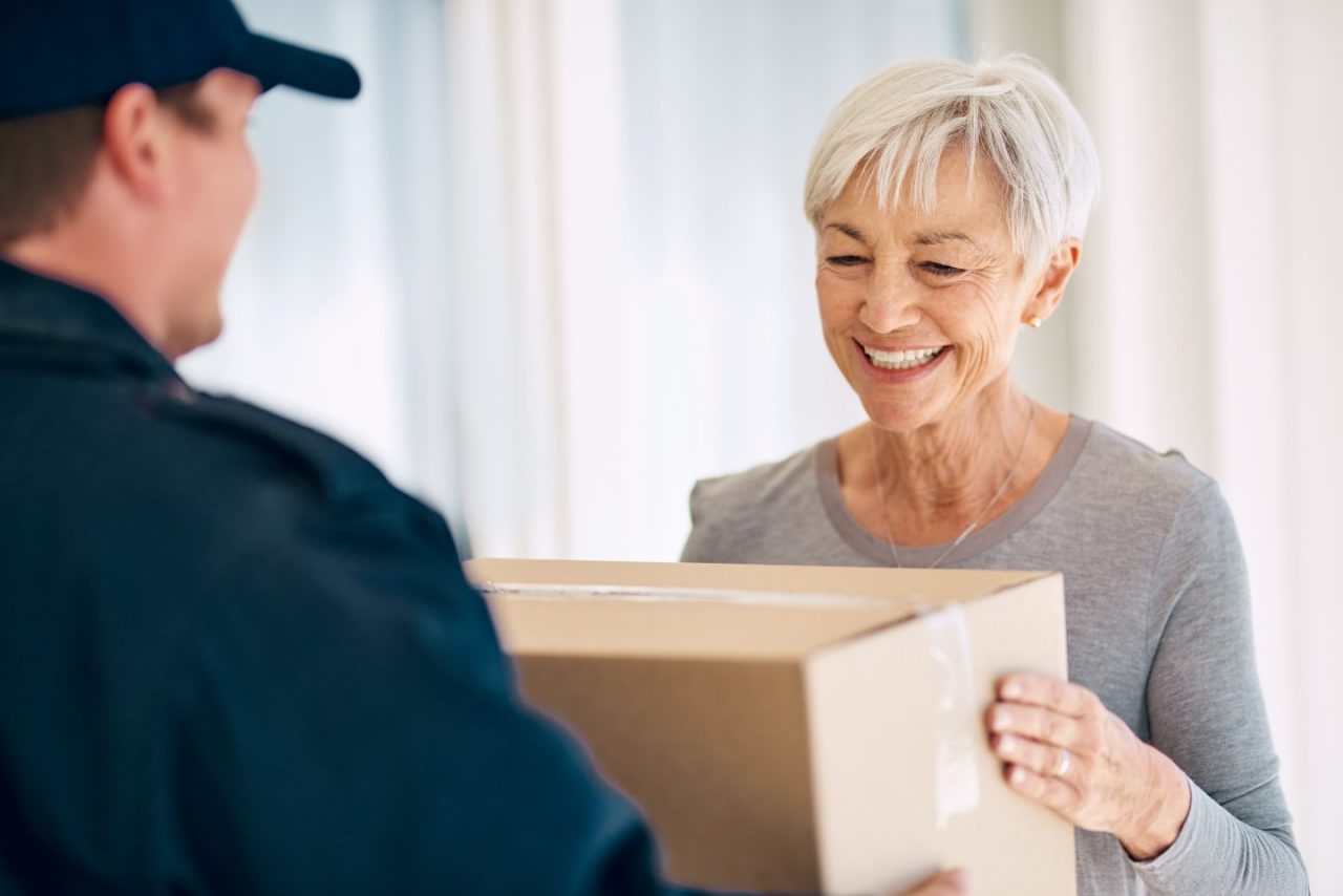 Paketbote übergibt Paket an Frau
